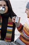 Young Couple drinking from metallic Cups - Gesture - Hot Beverage - Season - Beach