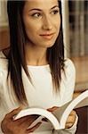 Darkhaired Woman looking up from her Novel - Print Media - Home