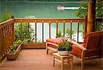 Blick auf das Deck und Stuhl mit Schwimmerflugzeugen Landung auf Big River Lake im Hintergrund Redoubt Bay Lodge in der Redoubt Bay State kritischen Lebensraum, Kenai, Alaska