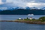 Aerial view of Point Retreat Light House at the tip of Mansfield Penninsula with Admiralty Island and a cruise ship in the background, Southeast, Alaska