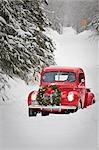 Homme conduisant un pick-up Ford de vintage 1941 avec une guirlande de Noël sur le front pendant l'hiver dans le centre-sud, Alaska