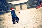 Portrait of girl infant wearing a Santa hat and walking in snow during Winter in Southcentral Alaska