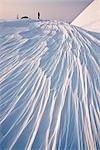 Bergsteiger genießt das Sonnenuntergang Licht auf dem Wind gebildet Sastrugi Formationen, Chugach National Forest, Alaska