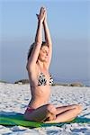 Frau praktizieren Yoga am Strand