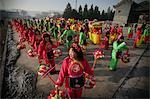 Colorfully dressed local women in a rural Chinese New Year Procession,at the valley of the Shi Li river located at the base of the Wuzhou Shan mountains,near Datong,Shanxi,China