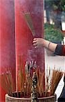 Frau holding Bunch of Rauchen Weihrauch klebt an Wong Tai Sin Temple, Hong Kong, China