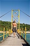 Male tourist on bridge to Nusa Cenida,Nusa Lembongan,Bali,Indonesia