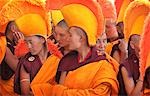 Nuns / monks in traditional dress with yellow orange hats and robes praying at 800 year old birthday celebration / rituals of the Buddhist Drukpa Lineage,Naro Photang Shey,(Shey Monastery),Leh Ladakh,Indian Himalayas,India