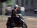 Femme d'aller pour travailler sur le scooter, Milan, Italie