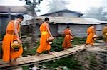 Novice monks out in early morning collecting alms at Wat Naluang,Luang Prabang,Northern Laos