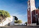 Silhouette of women carrying buckets on their head through square in front of the Chapel of Sao Paulo,Ilha de Mocambique,Mozambique.