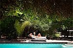 Woman sunbathing by swimming pool,Marrakech,Morocco