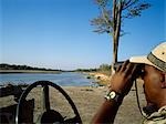 Safari guide looking,binoculars,Luwanga Valley National Park,Zambia