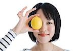 Femme tenant un citron à le œil