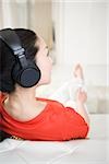 Woman listening to music on sofa