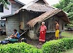 Femme de laver le linge à l'extérieur de la maison