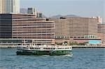 Star ferry en cours d'exécution dans le port de Victoria avec des bâtiments de l'hôtel à l'arrière-plan, Hong Kong