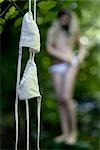 Bikini Top Hanging From Tree Branch, Woman in the Background