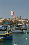 Brightly coloured fishing boats called Luzzus at the fishing village of Marsaxlokk, Malta, Mediterranean, Europe