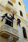 Men painting building without aid of scaffolding, Havana, Cuba, West Indies, Central America