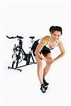 Woman Stretching by Stationary Bicycle