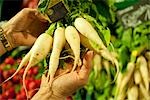 Personne qui détient des légumes au marché