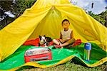 Boy with dogs in backyard tent