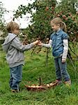 Girl and boy holding apples with basket