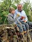 Man and boy avec pommes, assis sur les billes