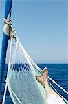 Woman's feet in hammock on sailing boat