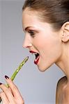 Female beauty model eating asparagus