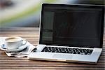 Laptop-Computer, Zeitung und eine Tasse Kaffee