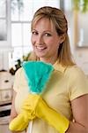 Woman Wearing Rubber Gloves and Holding Feather Duster