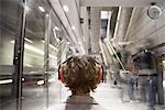 Woman Wearing Protective Headphones in Subway Station