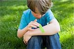 Boy putting plaster on arm