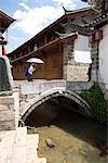 A young man walk across the bridge,Lijiang,China