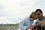 Father and son outdoors together looking at toy