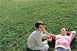 Mère et fille de détente sur l'herbe, ensemble fille regardant la caméra