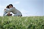 Fille embrassant son jeune frère en terrain herbeux
