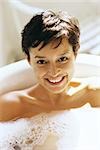 Woman enjoying bath, smiling at camera