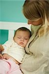 Young mother holding sleeping baby