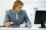 Homme d'affaires effectuant un achat en ligne avec carte de crédit