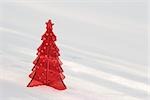 Red plastic Christmas tree decoration set in snow