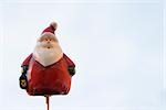 Santa Claus figurine on thin wooden post