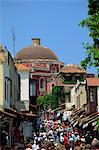 Tourists in busy back street with church dome behind, in the old town, Rhodes Town, Rhodes, Dodecanese Islands, Greek islands, Greece, Europe