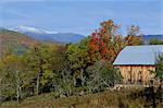 An old wooden farm building and trees in fall colours, with the White Mountains behind, near Jackson, New Hampshire, New England, United States of America, North America