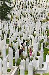 Femme et enfant tendent une tombe dans le cimetière de guerre, Sarajevo, Bosnie, Bosnie-Herzégovine, Europe