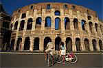 Couple admiring the Colosseum on bike ride, Rome, Lazio, Italy,Europe