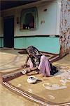 Woman painting the wall of a village house, Tonk region, Rajasthan, India