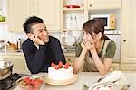 Front view of young couple celebrating with strawberry cake